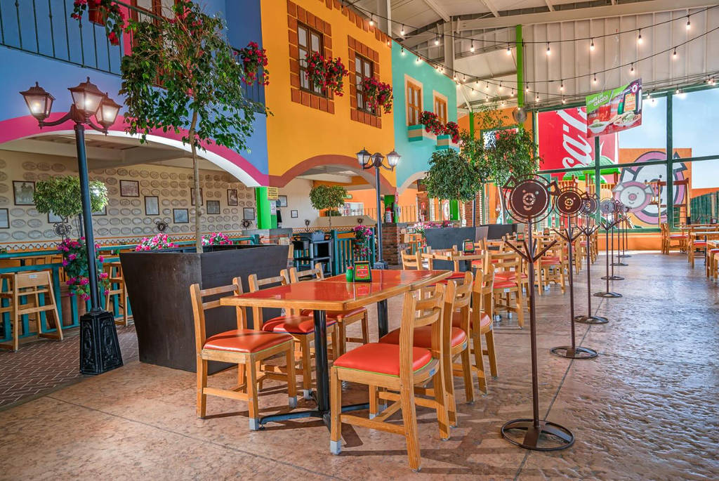 Image shows the interior of Los Cochinitos with tables and chairs.