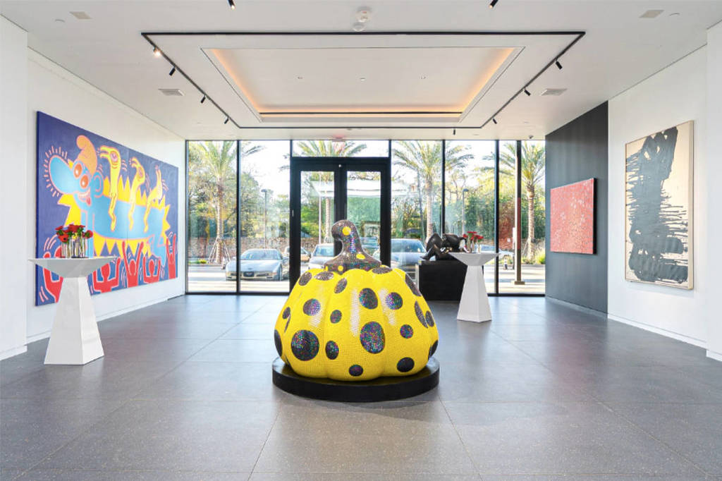 Image shows a viewing space at Opera Gallery Houston showcasing a piece by Yoyoi Kumasa flanked by paintings. 