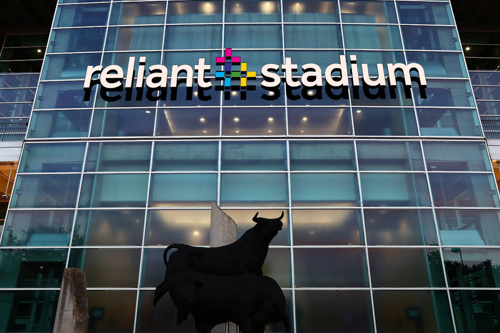 Image shows the Reliant Stadium entrance with a bull statue on the ground.