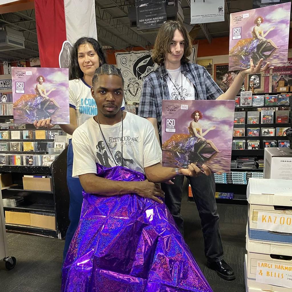 Image shows employees of Cactus Music store holding up vinyl copies of Sophie's '𝘖𝘪𝘭 𝘰𝘧 𝘌𝘷𝘦𝘳𝘺 𝘗𝘦𝘢𝘳𝘭’𝘴 𝘜𝘯-𝘐𝘯𝘴𝘪𝘥𝘦𝘴'