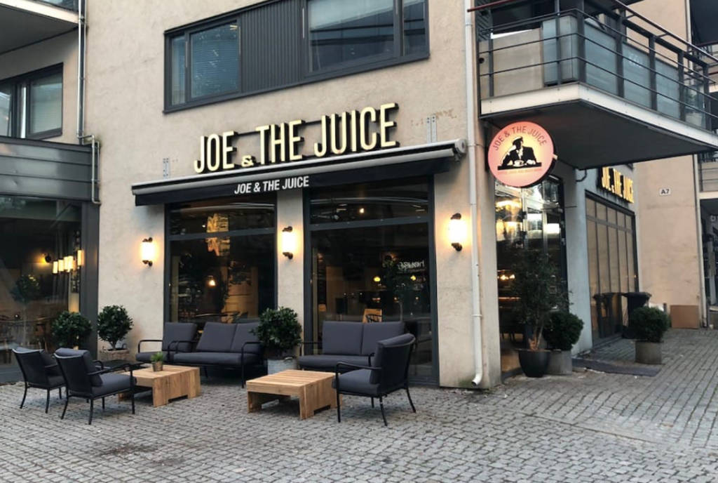 La imagen muestra el exterior de una cafetería Joe & The Juice.