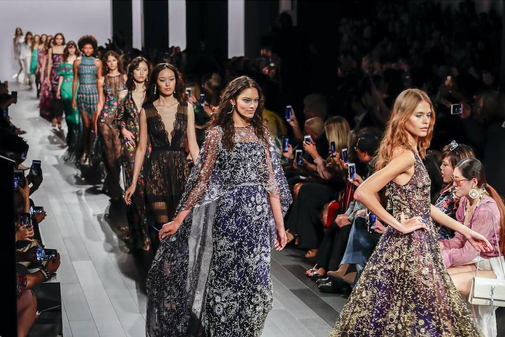La imagen muestra a modelos en una pasarela.