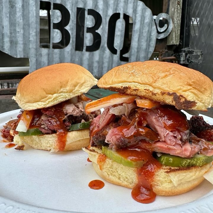 La imagen muestra un par de sándwiches de barbacoa que se ofrecen en Tejas Barbecue + Chocolate. 