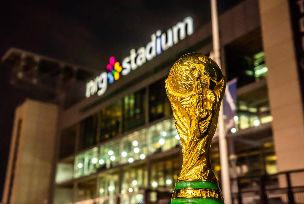 La imagen muestra el trofeo de la Copa del Mundo colocado frente al estadio NRG de Houston.