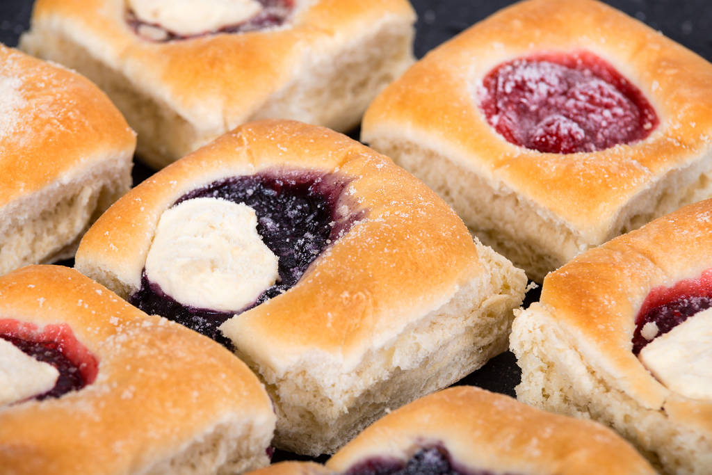 La imagen muestra una selección de kolaches de fruta.