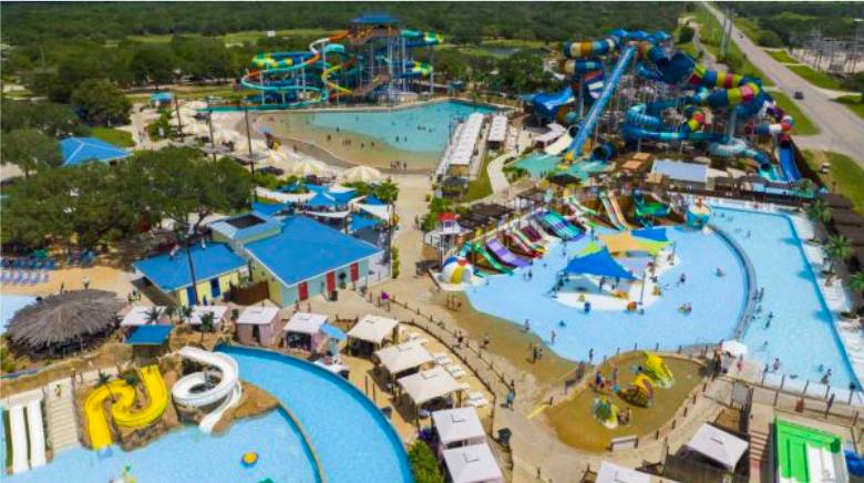 La imagen muestra una vista aérea del parque acuático Splashway en Sheridan, Texas. 