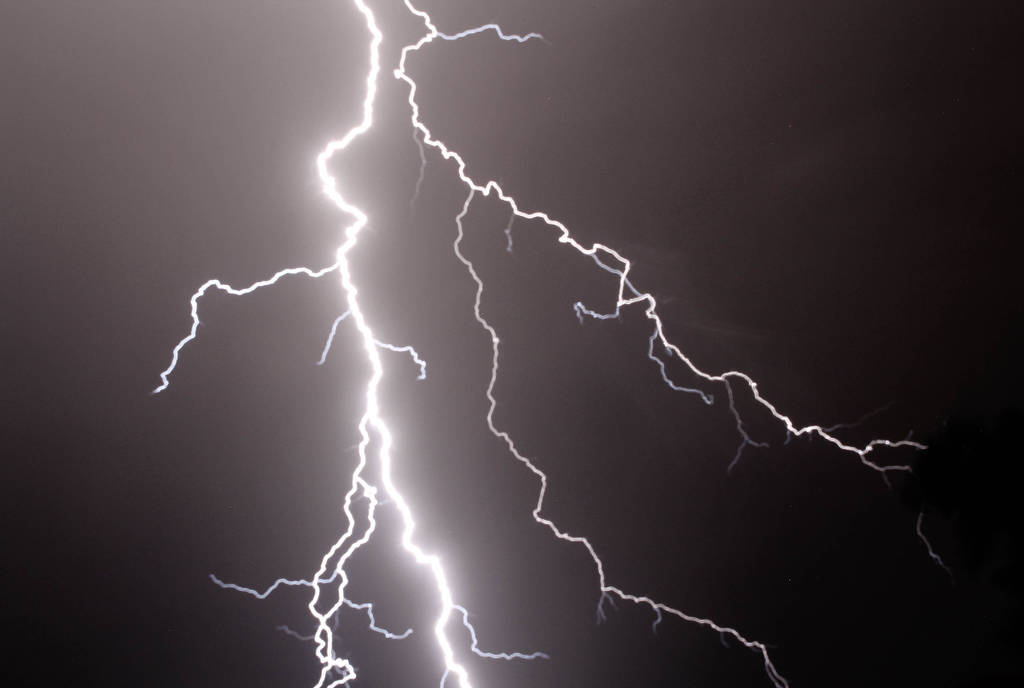 La imagen muestra un rayo en un cielo oscuro. 