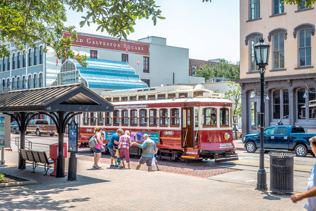 Image shows people boarding a Galveston trolley. 
