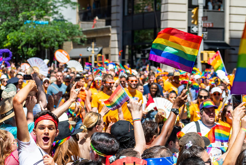 Image shows people celebrating at a Pride festival.