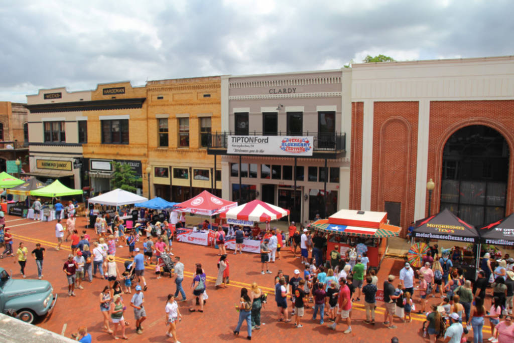 La imagen muestra el centro de Nacogdoches con asistentes y visitantes del Festival del Arándano de Texas. 