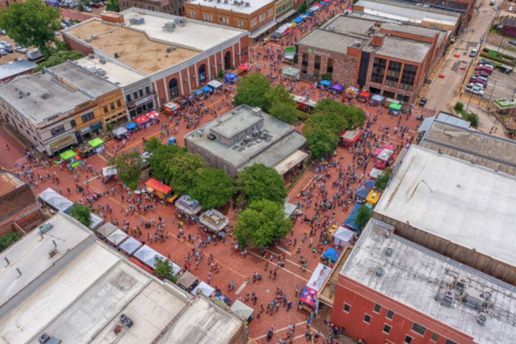 La imagen muestra el centro de Nacogdoches con participantes y visitantes del Festival del Arándano de Texas.