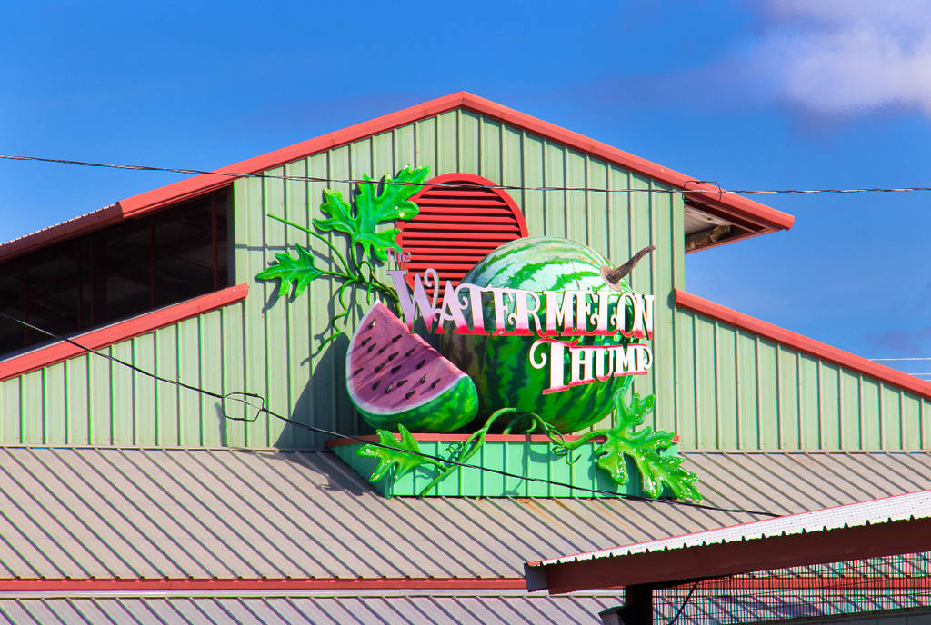 Image shows a building in Luling, Texas featuring a large watermelon installation advertising Watermelon Thump.