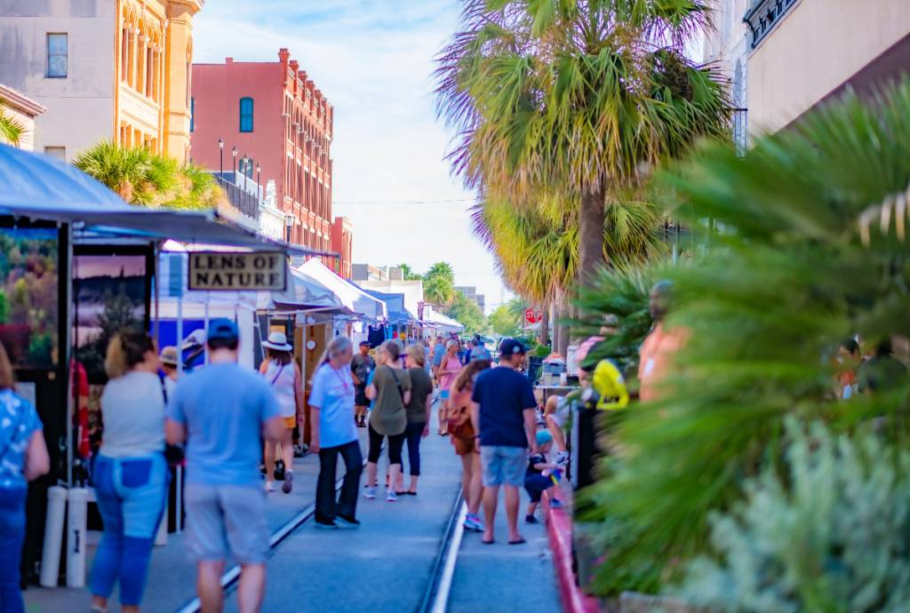 La imagen muestra a gente visitando un festival en Galveston. 