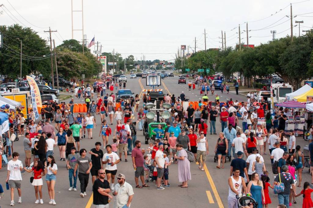 La imagen muestra el festival callejero del 4 de julio de Tomball con las calles repletas de gente.