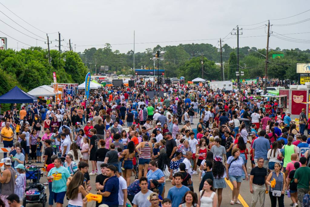 Image shows the Tomball 4th of July street festival with crowded streets.