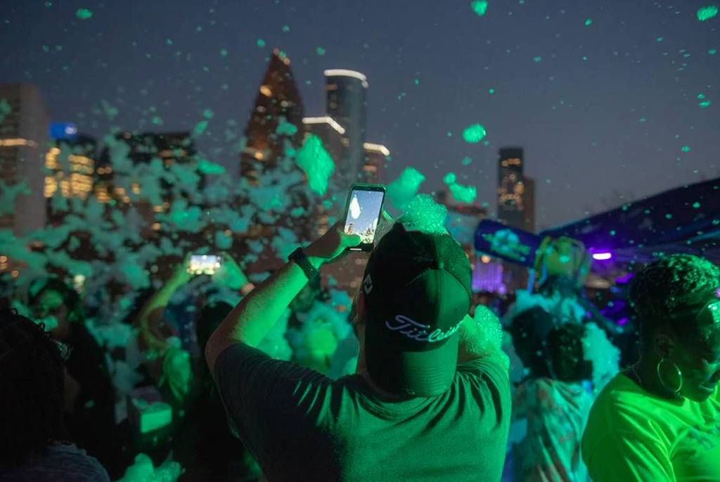 Image shows a foam party at POST Houston rooftop. 