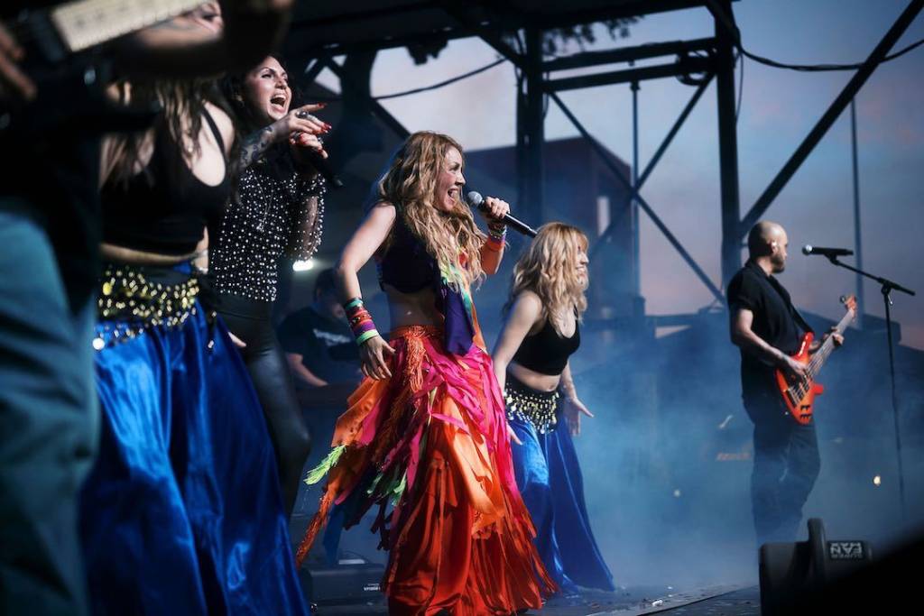 Image shows a Shakira tribute act performing on stage at Liberty Fest. 