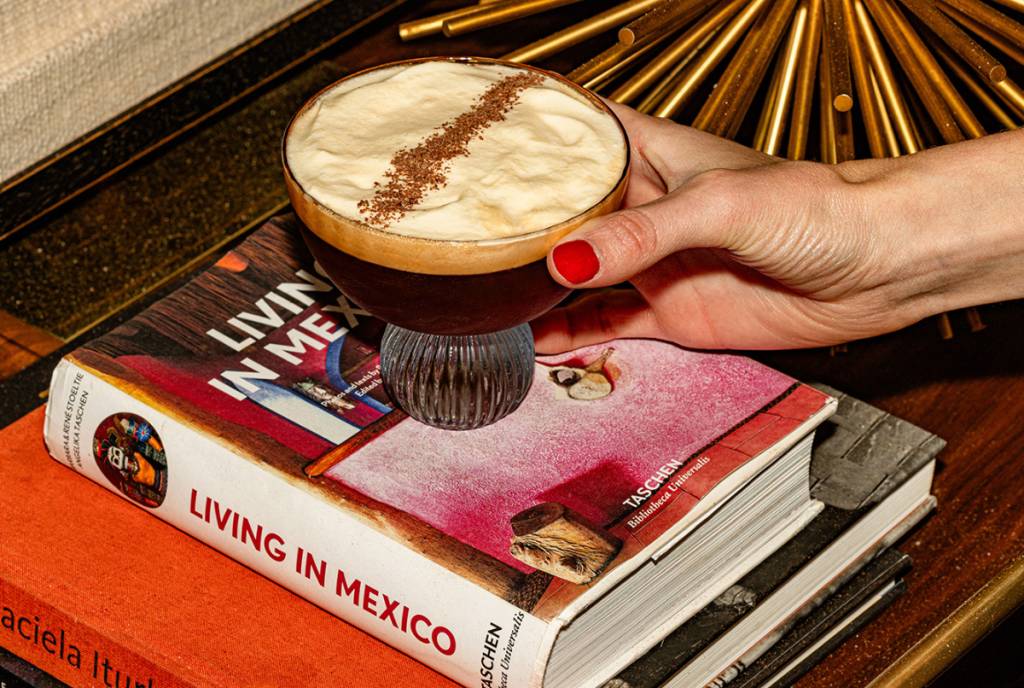 Image shows a coffee-based cocktail set on a book. 