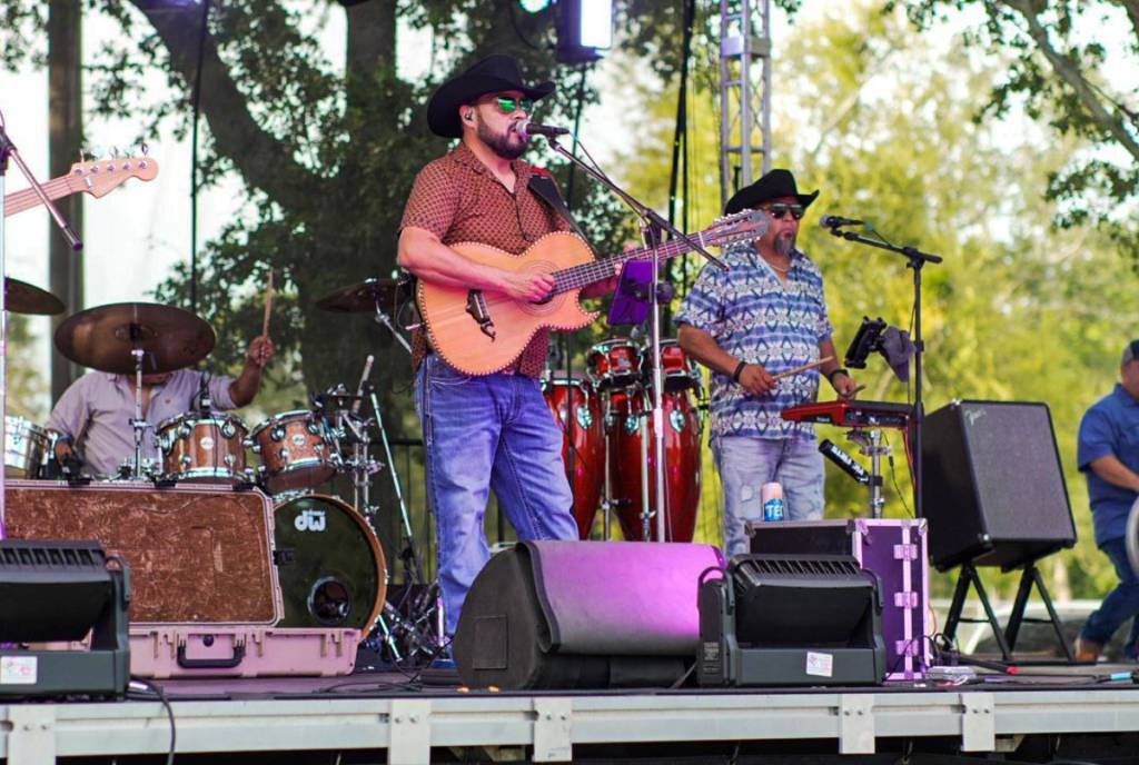 Image shows a band performing on stage at Great Texas Mosquito Festival in Clute, Texas. 
