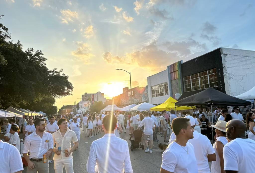 La imagen muestra una gran multitud de gente en la calle West 19th Street, en The Heights, durante la «White Linen Night».
