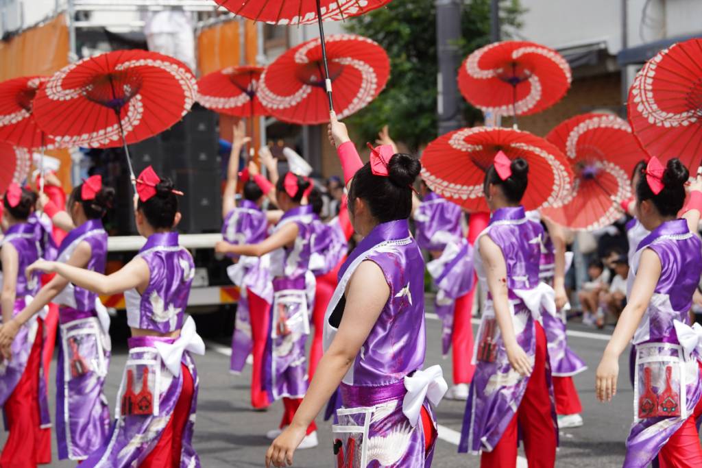 La imagen muestra a un grupo de mujeres con trajes tradicionales japoneses durante un festival.