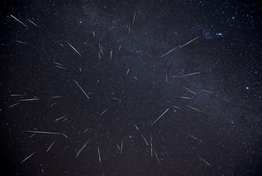 Image shows a meteor shower in the night sky.