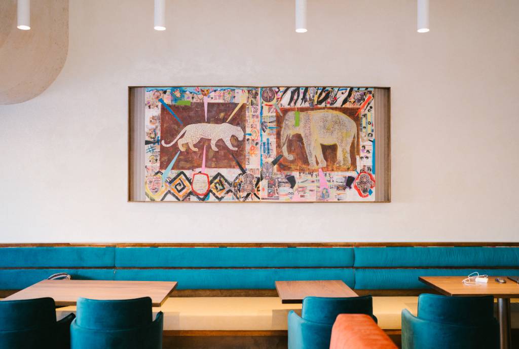 La imagen muestra el comedor y las obras de arte de Late August en Houston.