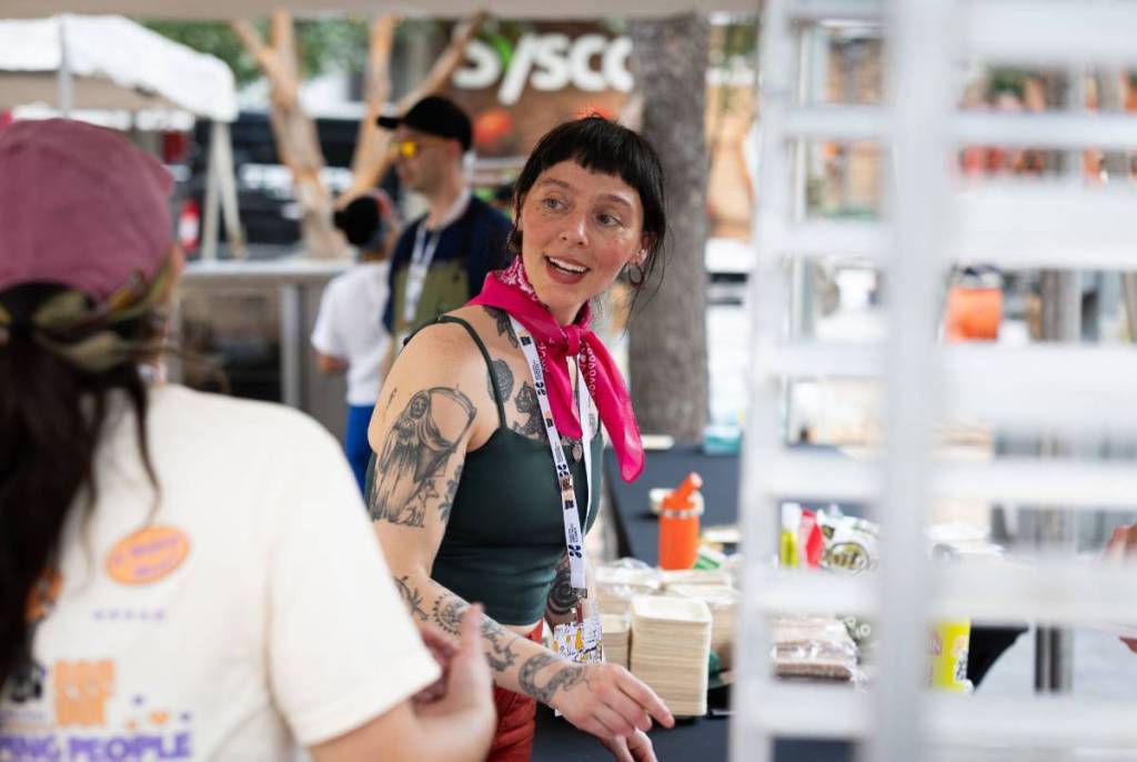 Image shows Chef Maria Camacho talking to someone at the Southern Smoke Festival in Houston.