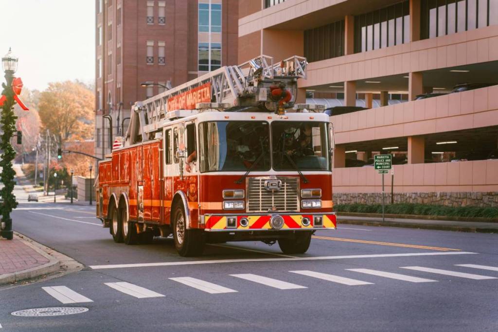 La imagen muestra un camión de bomberos circulando por una calle. 