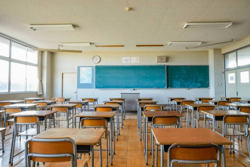 La imagen muestra un aula vacía. 