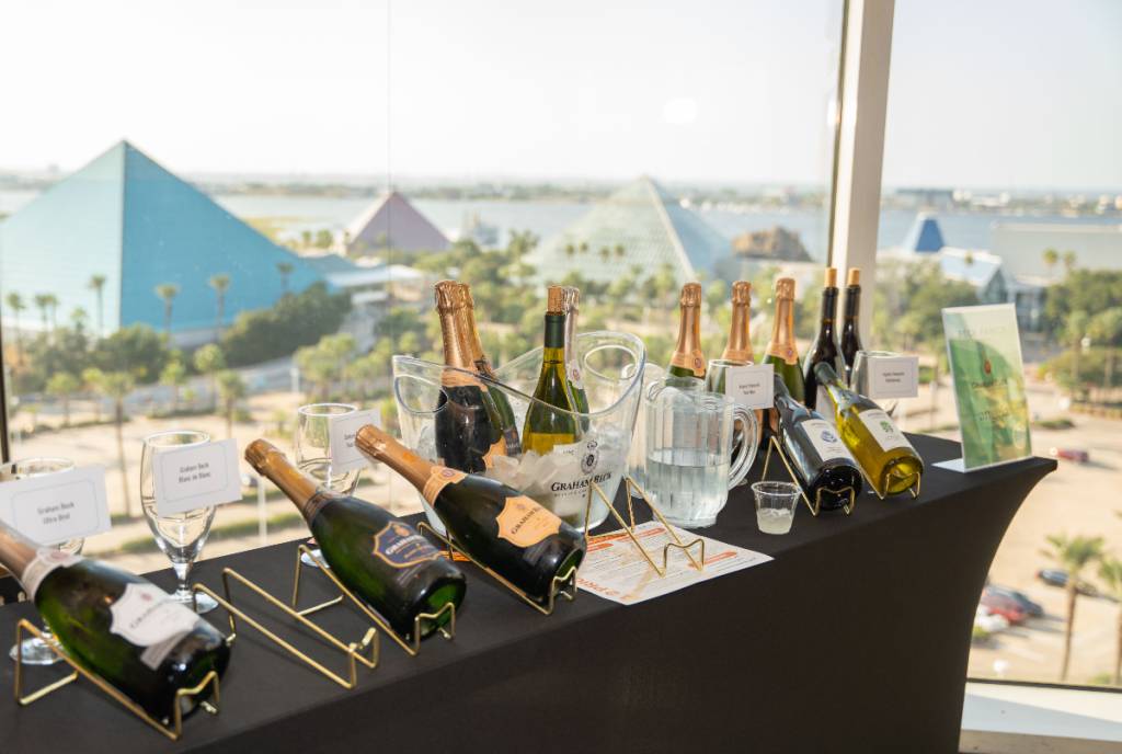 Image shows a table of wines with the Moody Gardens pyramid in the background.