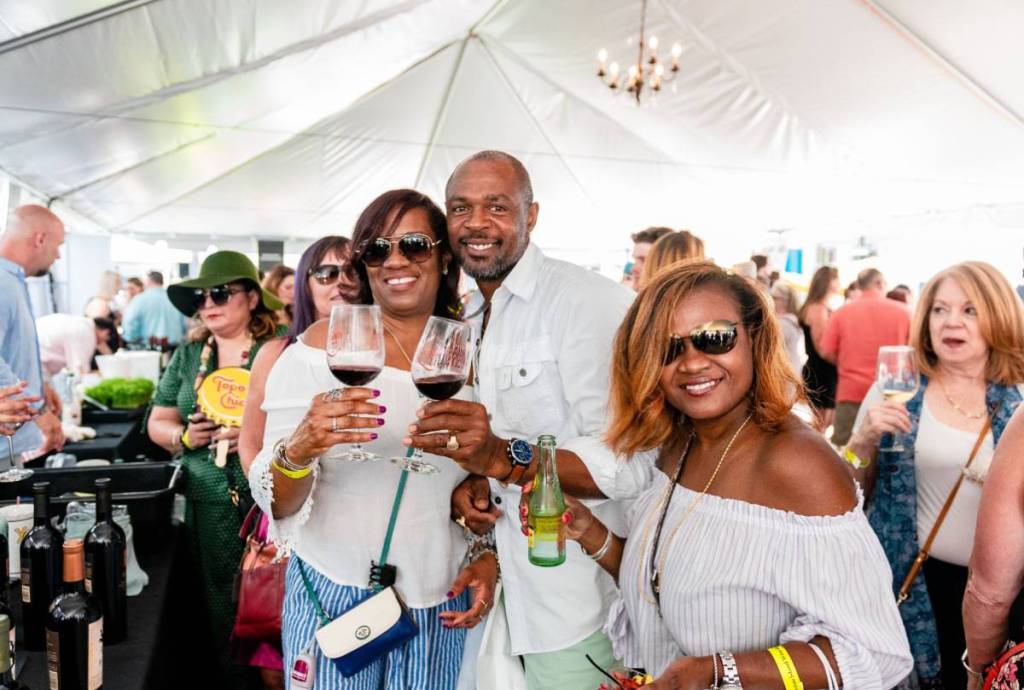 Image shows participants of the Galveston Island Wine Festival posing for a photograph. 