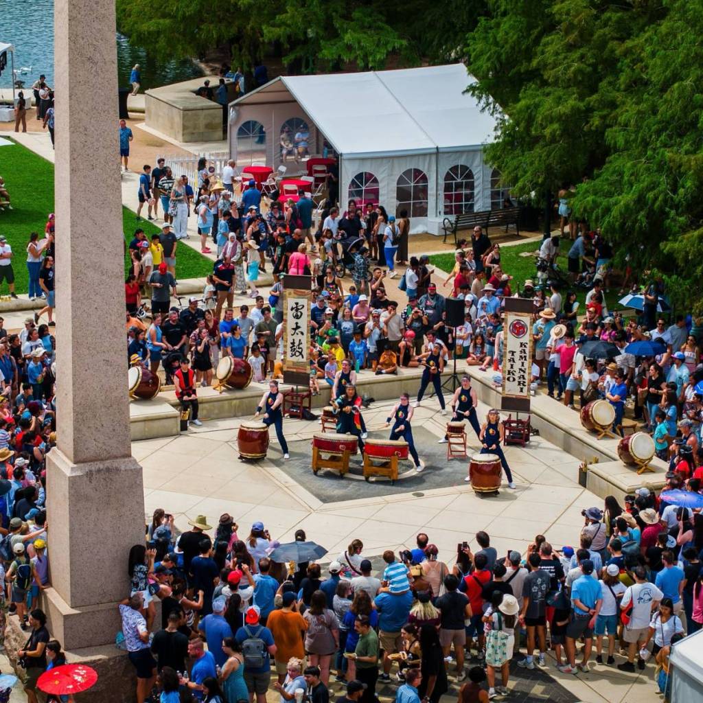 Image shows a large crowd watching an event at the Japan Festival Houston.