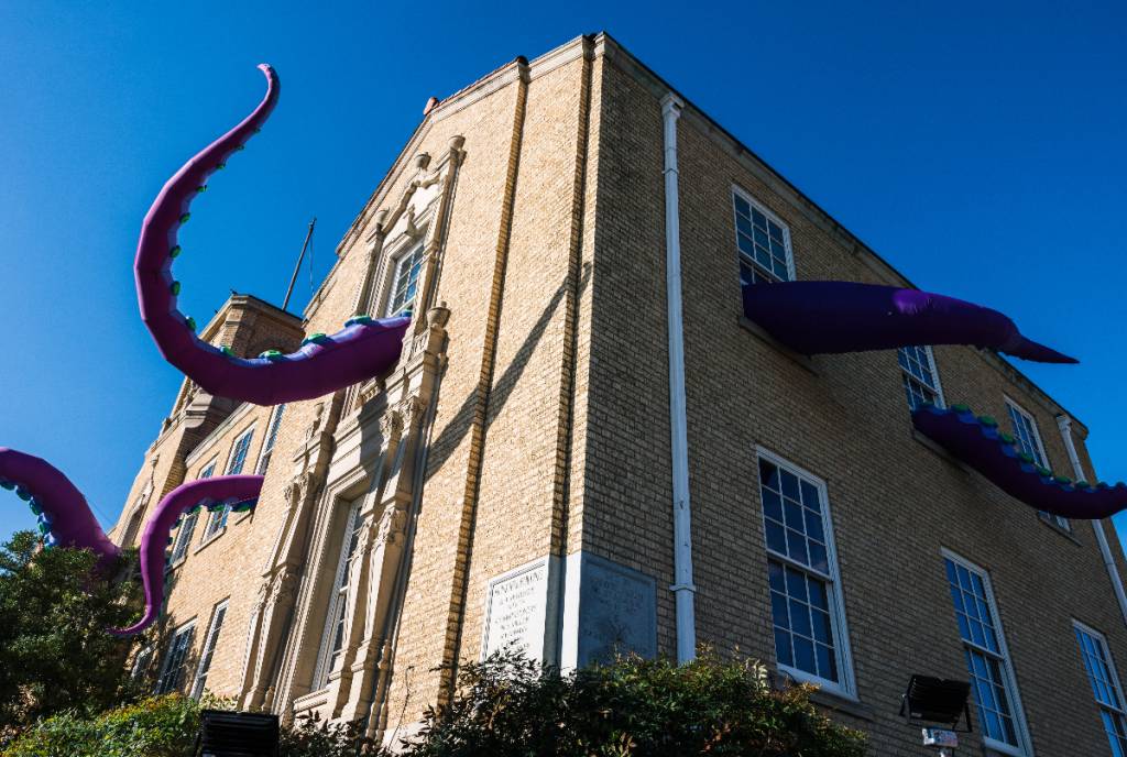 La imagen muestra un edificio con una instalación de un monstruo a gran escala con tentáculos que salen por las ventanas en Denton, Texas.