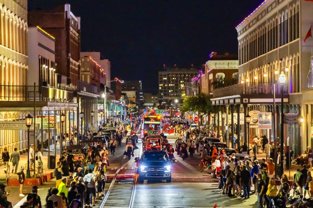 La imagen muestra el «Mystical Parade of Boo» en Galveston, Texas, por la noche.