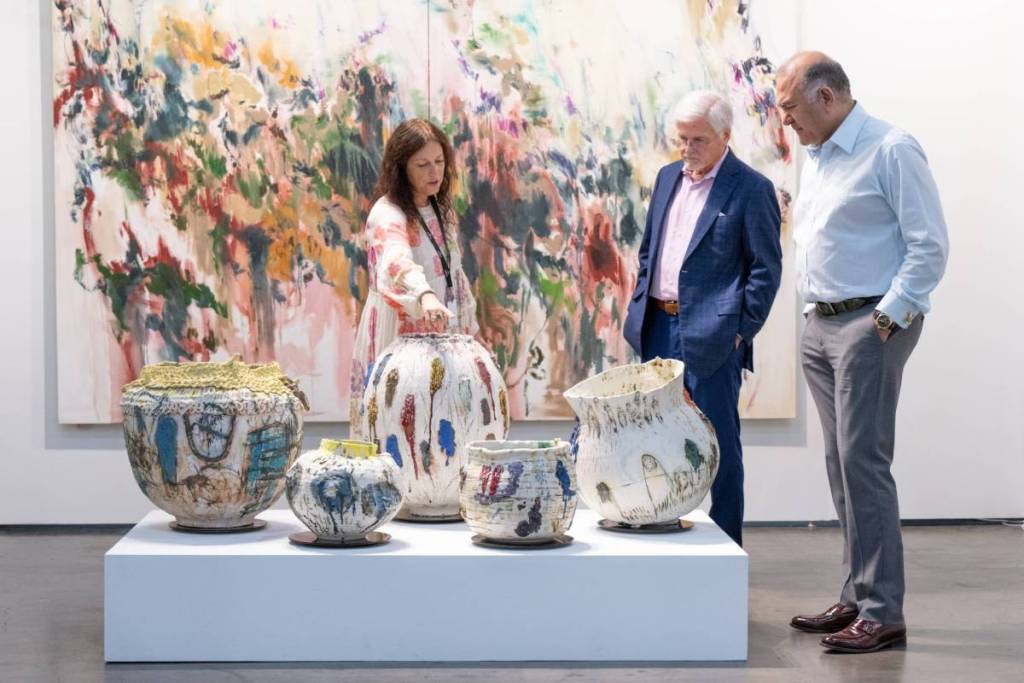 La imagen muestra a gente admirando piezas de arte en cerámica en Untitled Art, Houston.