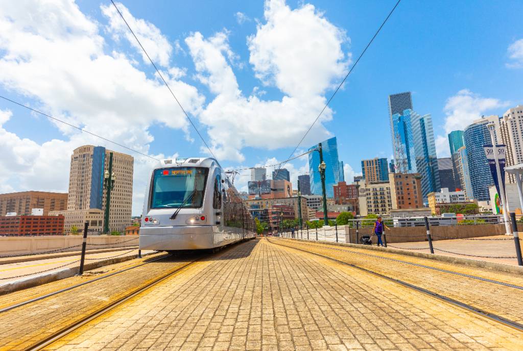 La imagen muestra el metro con el perfil de la ciudad al fondo.