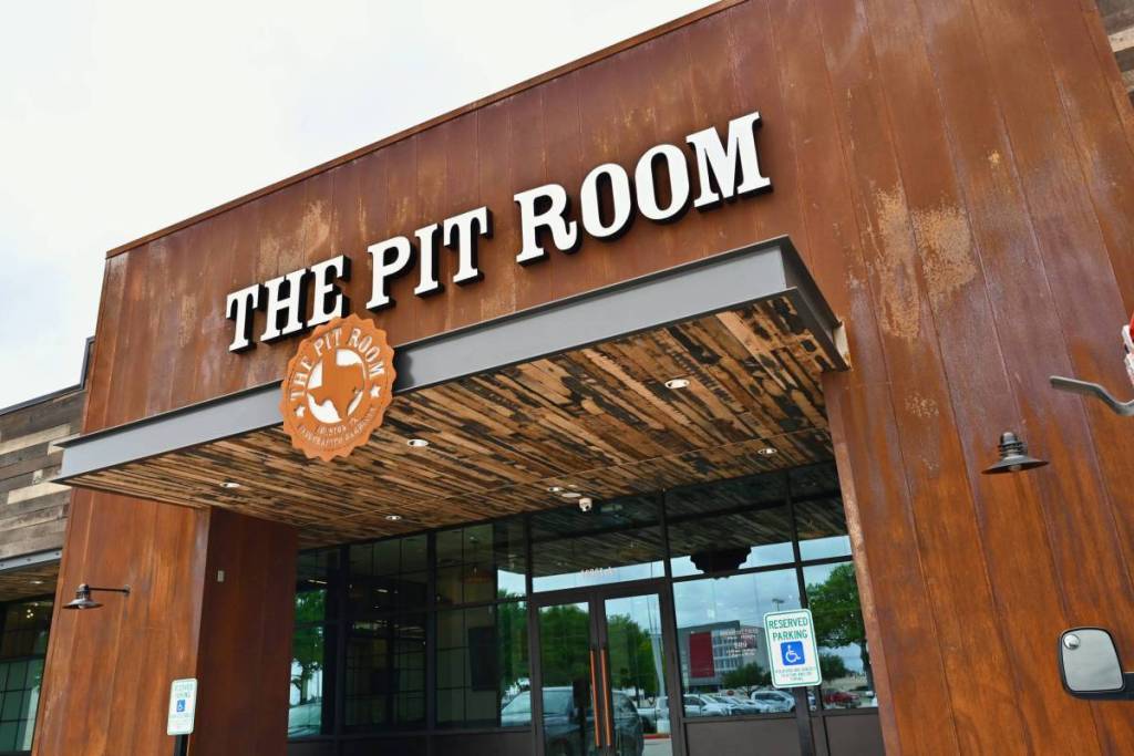 La imagen muestra el exterior de The Pit Room en Memorial, Houston.