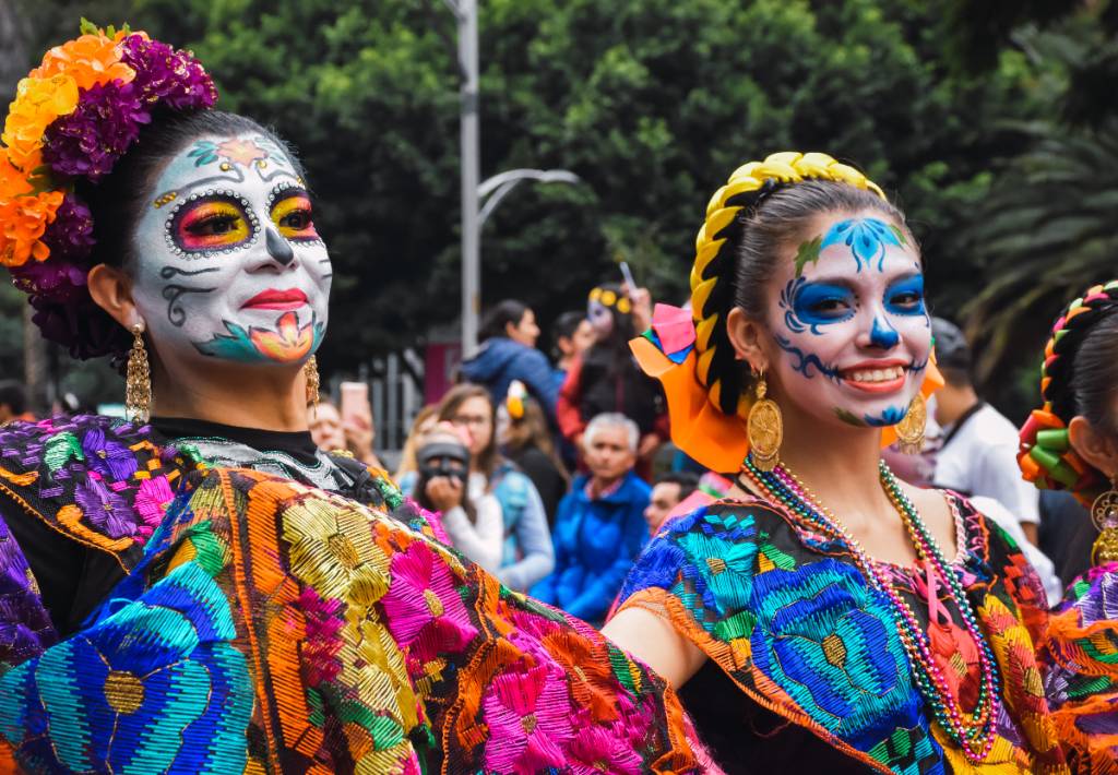 La imagen muestra un desfile del Día de los Muertos.