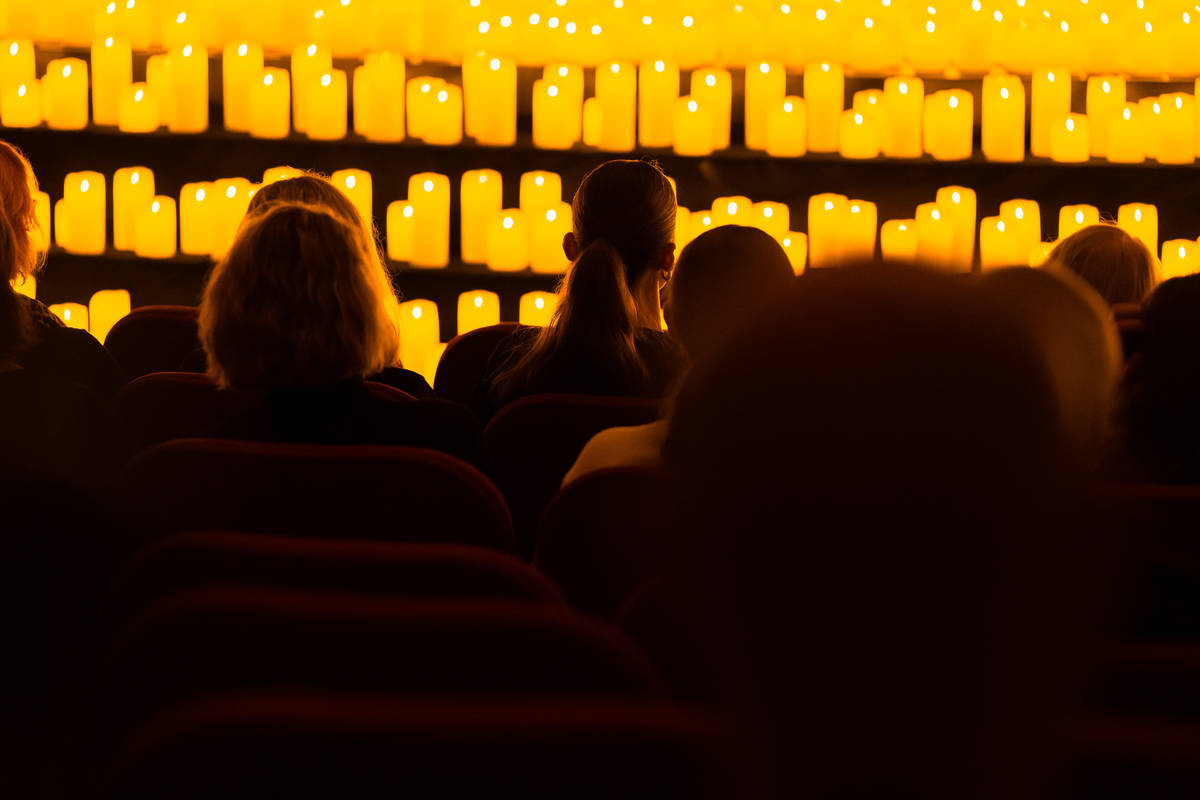 Sileutas de la primera fila de espectadores viendo un concierto Candlelight.