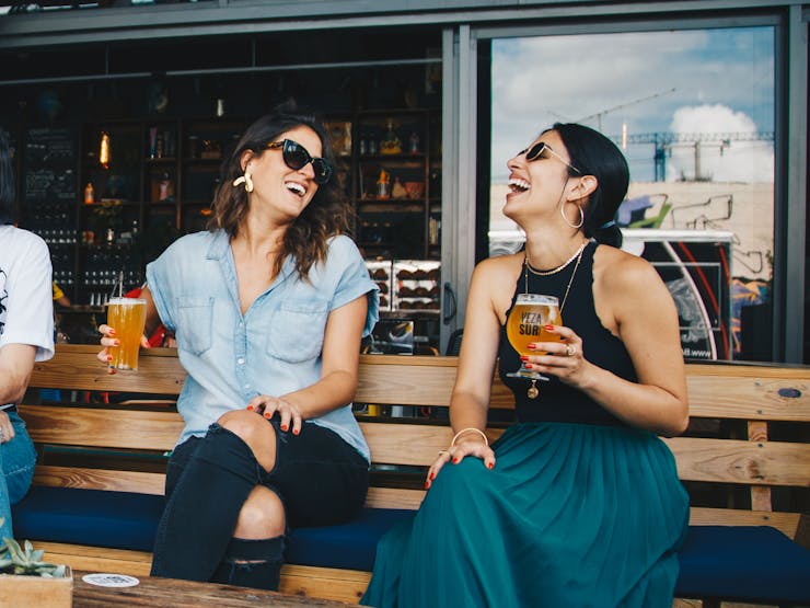 girls having beers and laughing