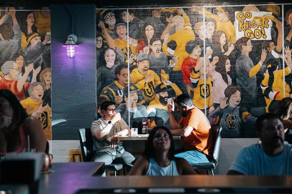 people at a sports bar in Vegas with a Knights themed wall