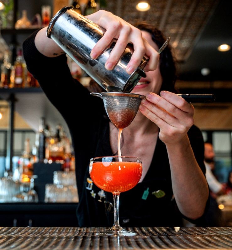 woman making a orange-red cocktail