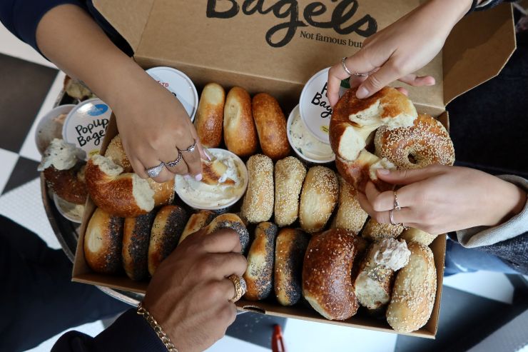 people dipping bagels in cream cheese