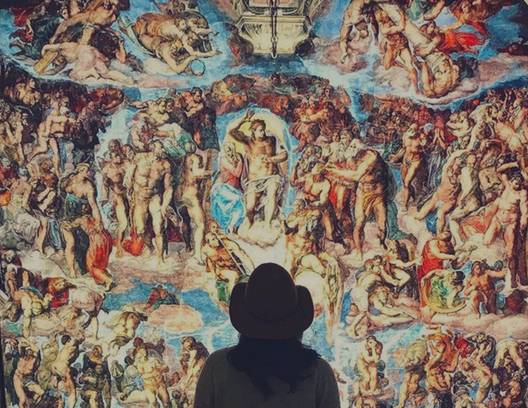 girl looking at a Sistine Chapel art piece in an exhibition
