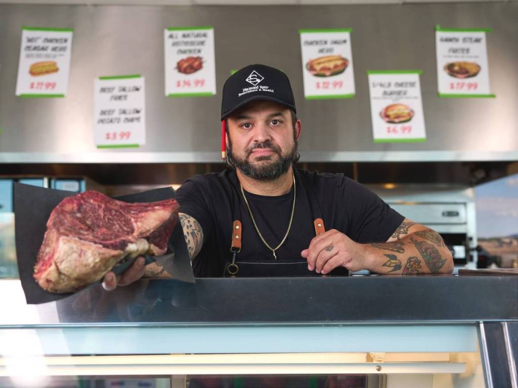 un chef y un trozo de carne en una charcutería
