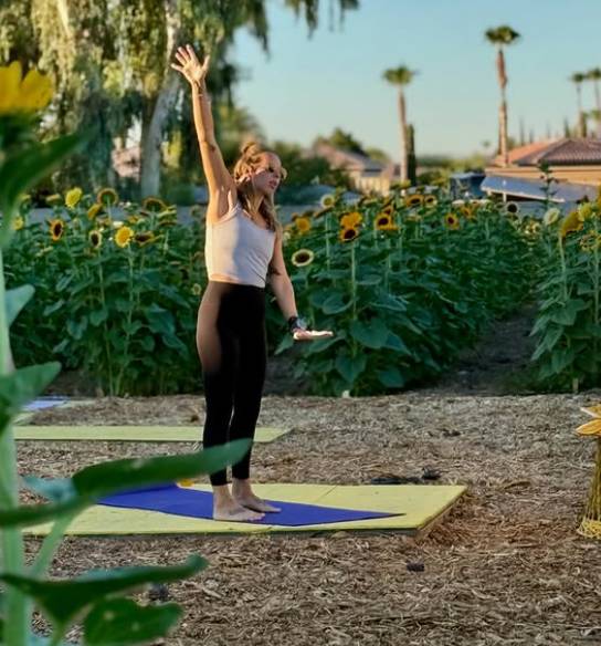 woman doing yoga in a sunflower field