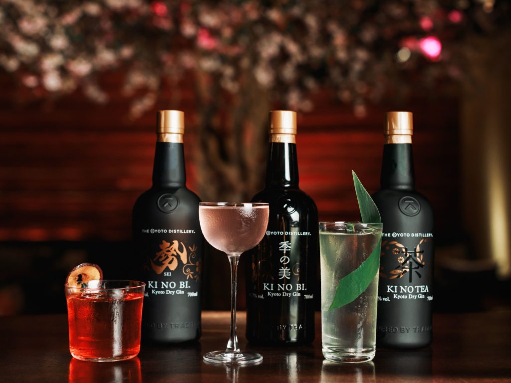 a selection of gins with cocktails presented in front of them