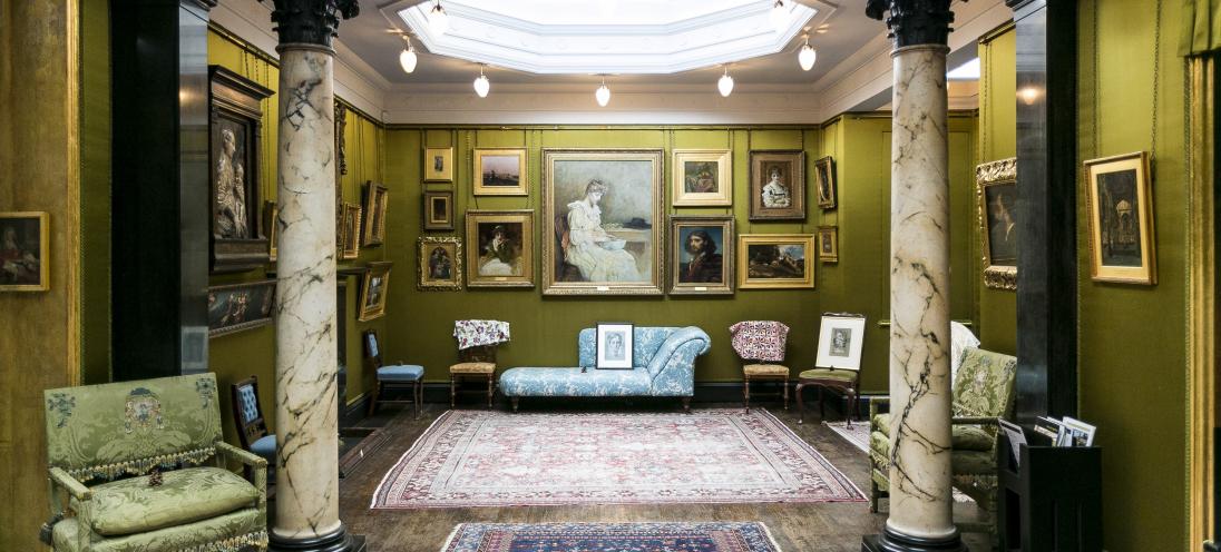 a room adorned with a plethora of framed paintings and various seating areas