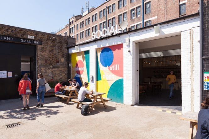 People enjoying a drink in the sunny courtyard outside Social in Peckham